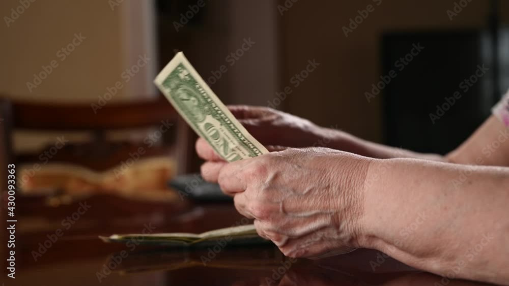 Small pension concept. Woman counts on the dollar Small pension concept. Woman counts on the dollar