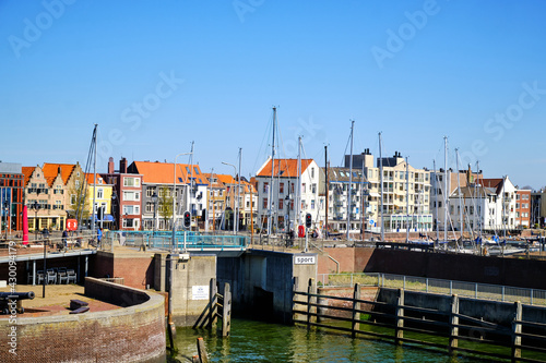 View of the harbor with sailing yachts and historical houses in the background. Location is the dutch town Vlissingen in the province Zeeland. Popular town for beach and summer. photo