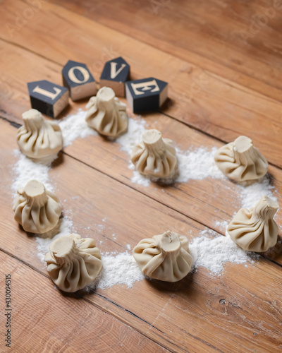 Khinkali in shape of a heart on a wooden table. Valentines Day concept, love for food.