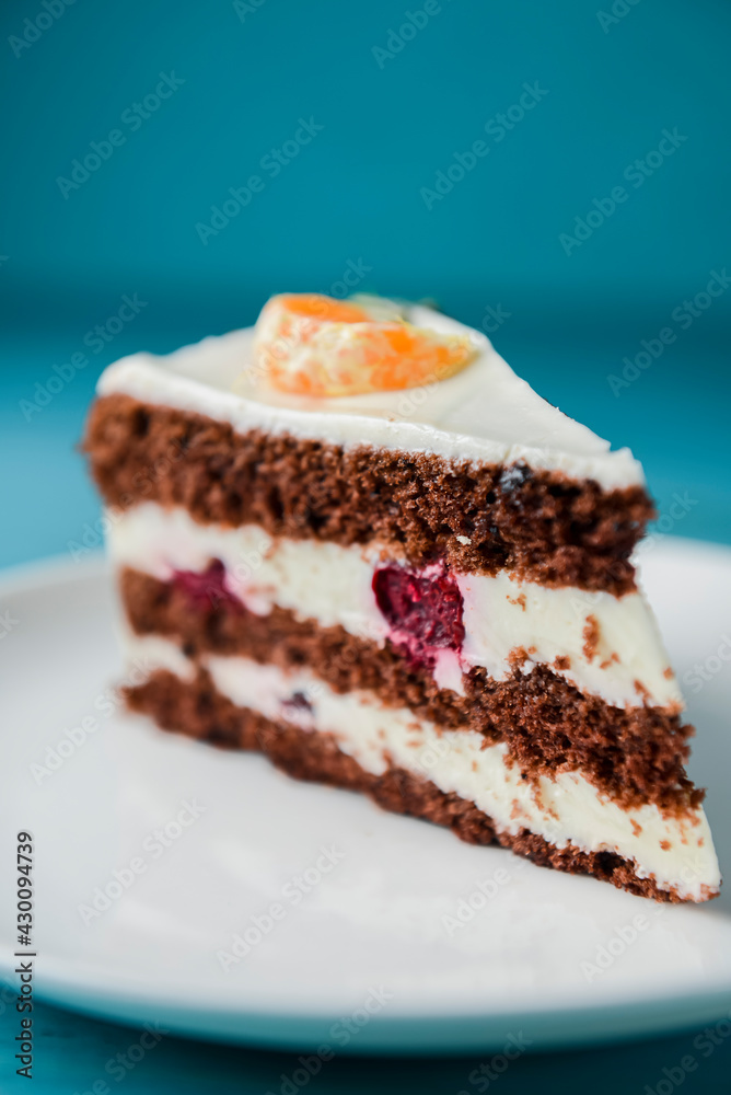 A piece of chocolate cake with vanilla cream. Berries inside and a piece of tangerine on top. A piece of chocolate cake with vanilla cream. Berries inside and a piece of tangerine on top.