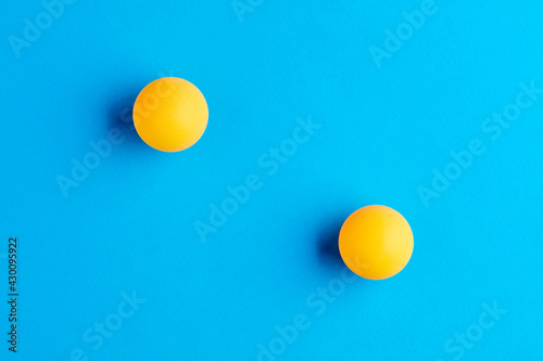 Two orange table tennis balls opposed to each other