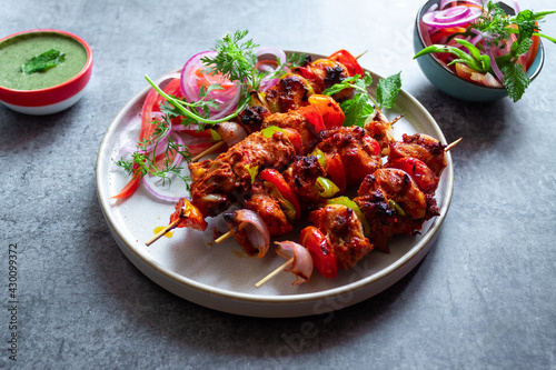 Chicken Skewers with some a side salad on a plate
