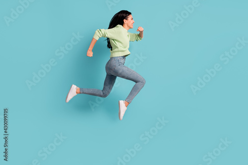 Full size profile portrait of excited lady jumping running look empty space isolated on blue color background