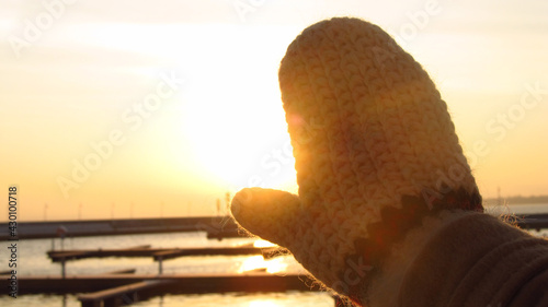 Rękawiczka na tle wschodu słońca nad morzem
