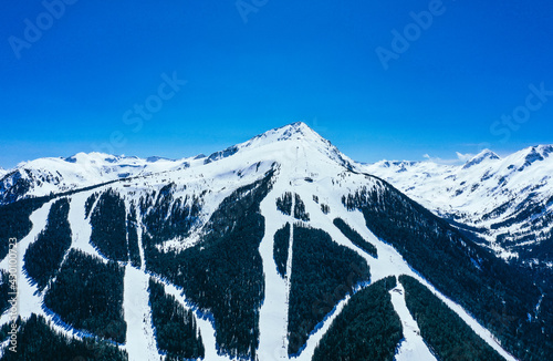 Balkans, Todorka mountain peak, ski tracks, covered with snow. Beautiful alpine natural winter backdrop. Pirin ice top of the hill on the blue sky background.
 photo