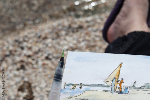 Sea sketch in watercolor. Artist painting landscape open air on beach. selective focus. High quality photo