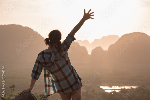 Happy slim hipster girl is standing on view point against sea and islands at sunrise. Phang Nga bay, Thailand