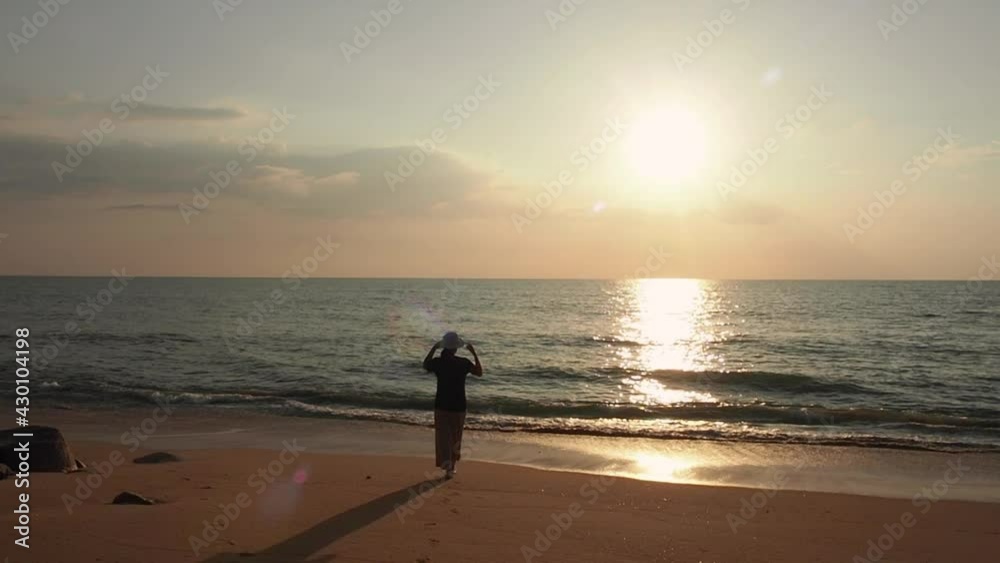 sunset or sunsrise at the sea. beautiful sunlight shine in long path on water surface with silouatte of a woman relaxing on the beach. romantic nature sceanery. sunset or sunsrise at the sea. beautiful sunlight shine in long path on water surface with silouatte of a woman relaxing on the beach. romantic nature sceanery.