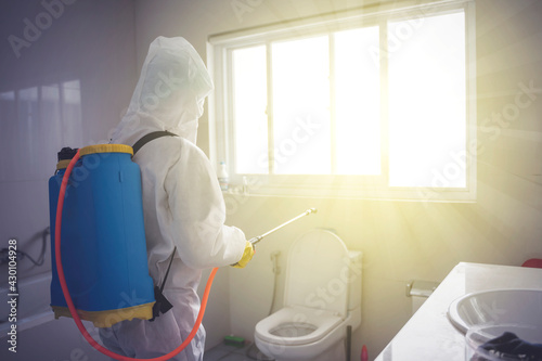 Fotografía Young man cleaning bathroom with disinfectant spray