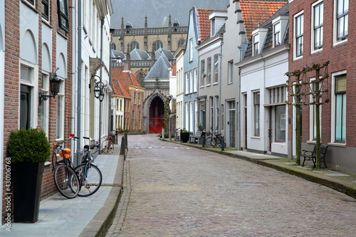 Colorful house facades on Kerkstraat street in Zaltbommel, North Brabant, Netherlands, a fortified city located 15km far from Hertogenbosch, with Sint Maartenskerk church in the background photo