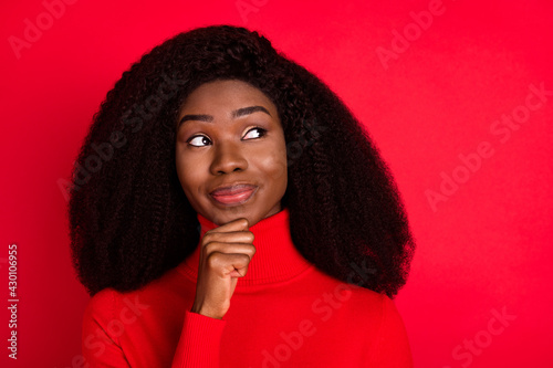 Photo of young african woman happy positive smile hand touch chin think dream look empty space isolated over red color background