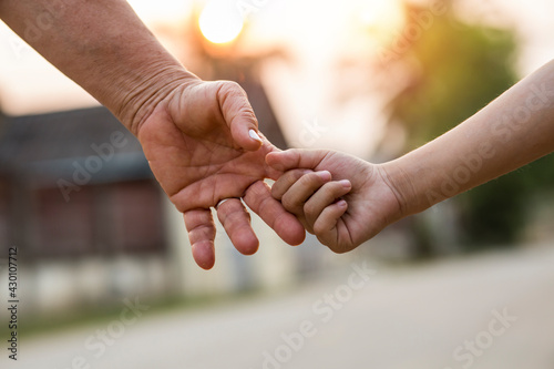 parent holds the hand of a small child