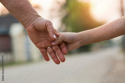 parent holds the hand of a small child © maeching
