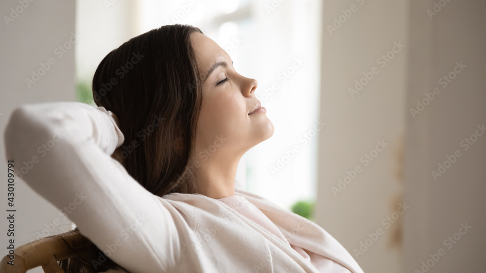 Relaxed peaceful young woman with closed eyes breathing fresh air at home. Happy freelancer, student girl resting in armchair, enjoying lazy break, leisure time in weekend. Stress relief concept Relaxed peaceful young woman with closed eyes breathing fresh air at home. Happy freelancer, student girl resting in armchair, enjoying lazy break, leisure time in weekend. Stress relief concept