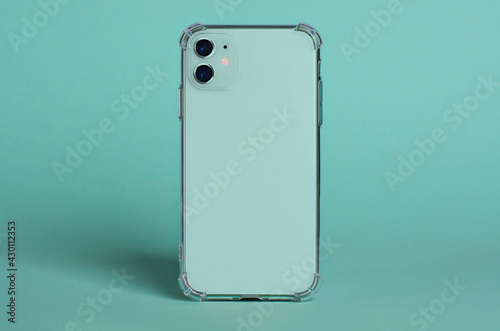 Green smartphone in clear silicone case back view. iPhone 11 case mockup isolated on green background