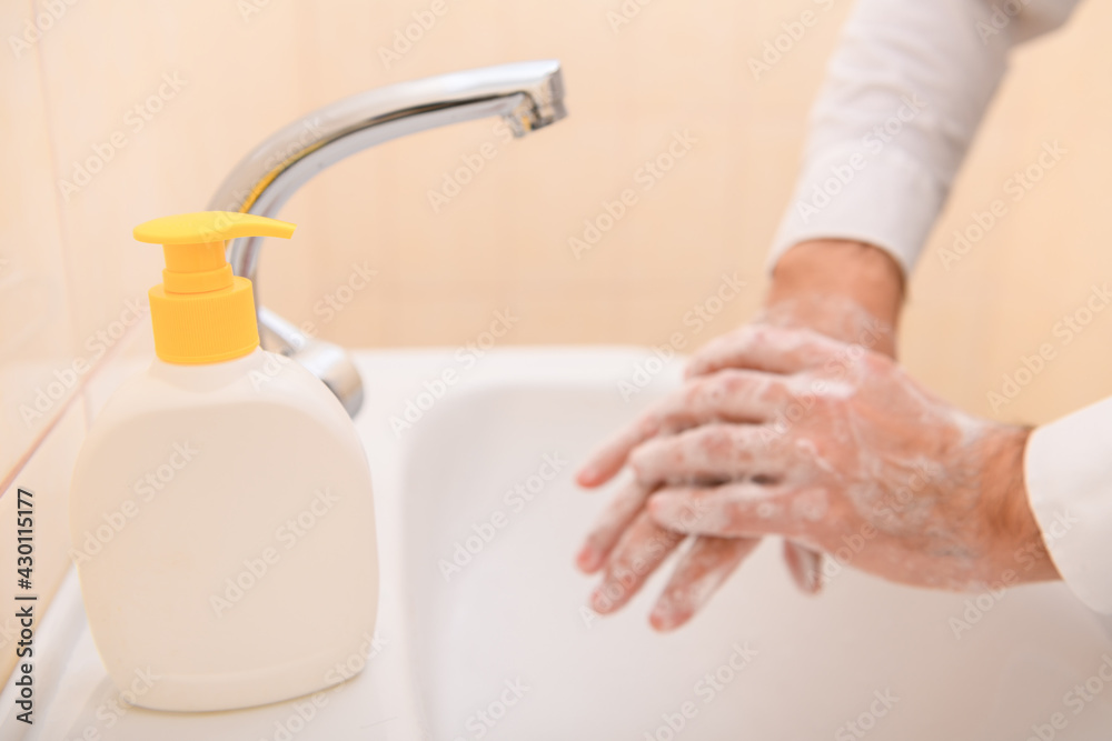 hand washing with soap or gel under running water in the washbasin, cleanliness and hygiene, men's hands dressed in a white shirt hand washing with soap or gel under running water in the washbasin, cleanliness and hygiene, men's hands dressed in a white shirt