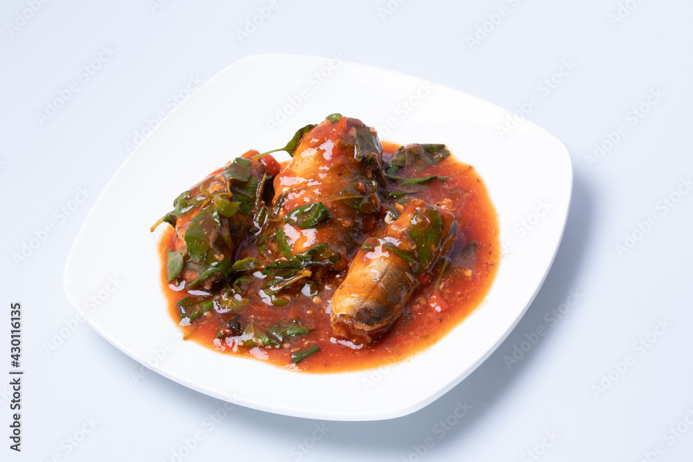 Stir-fried spicy canned fish with basil leaves served Sardines in tomato sauce fried with spicy basil. Thai style food.Clipping Path Stir-fried spicy canned fish with basil leaves served Sardines in tomato sauce fried with spicy basil. Thai style food.Clipping Path