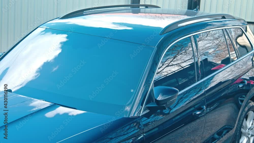 The reflection of clear sky on black car hood