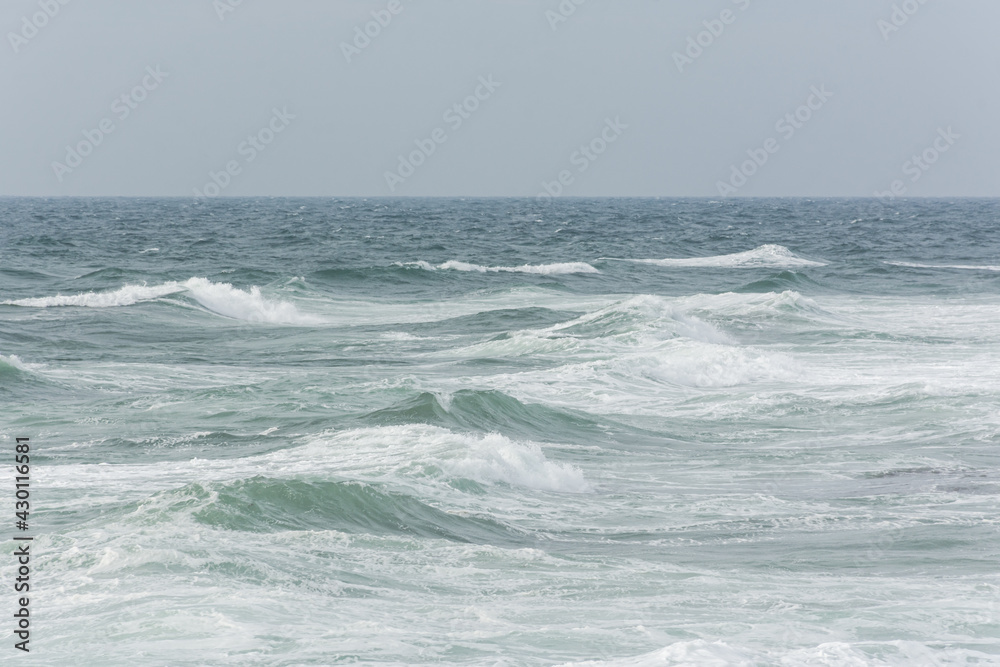 Pastel-gray sea. texture of a raging ocean, full frame with space for text. The concept of weather, vacation, travel. The purest clear sea water, big waves close-up. Calm natural light gray background