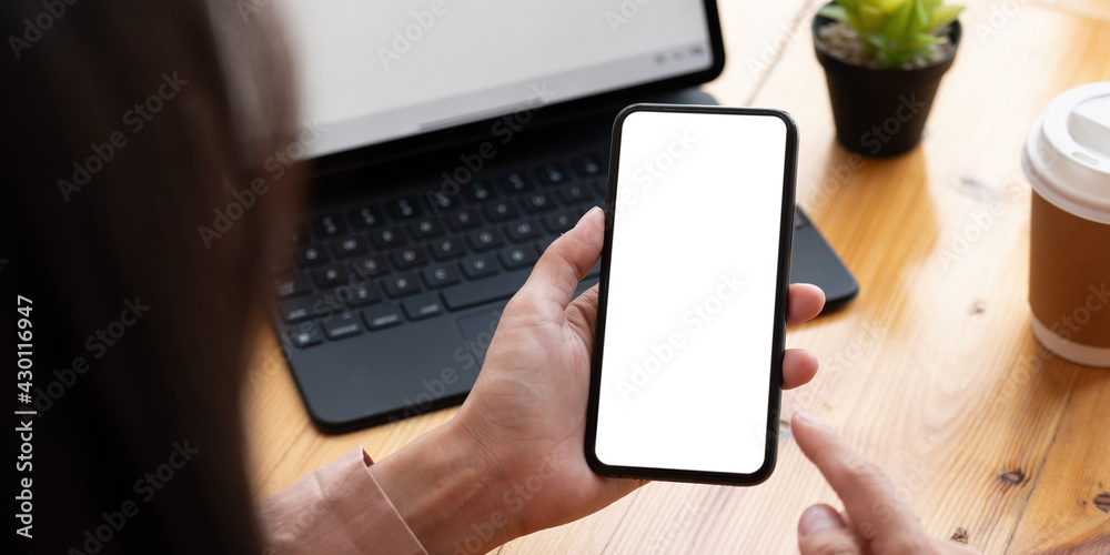 Top view Woman sitting on work desk and holding blank screen mock up mobile phone. Top view Woman sitting on work desk and holding blank screen mock up mobile phone.