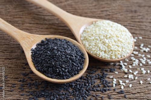 Black (Poppy) and white sesame seeds in wooden spoon on wooden background,Copy space,Close up.
