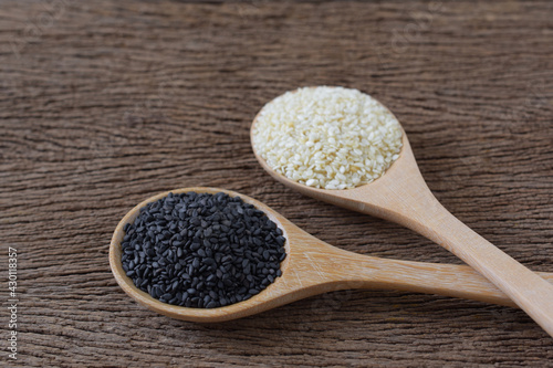 Black sesame (Poppy) and white sesame seeds in wooden spoon on wooden background,Copy space,Close up.