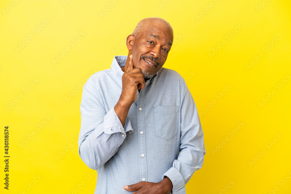 Cuban Senior isolated on yellow background and thinking Cuban Senior isolated on yellow background and thinking