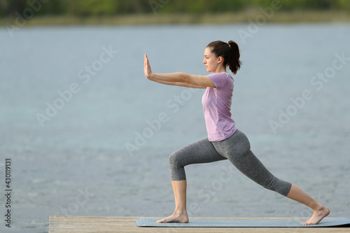 Side view of a woman doing tai chi exercise in a lake