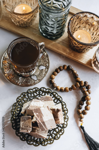 bowl with various pieces of Turkish delight locum and black tea with mint on a light background. Oriental sweets. copy space. Top view.