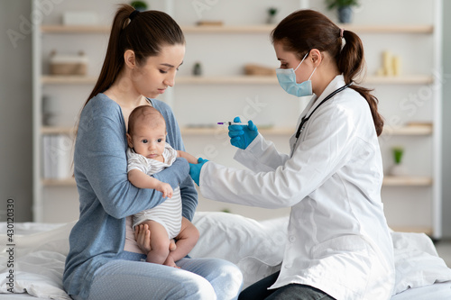 Children Vaccination. Doctor Doing Immunity Strengthening Injection For Newborn Baby At Home © Prostock-studio