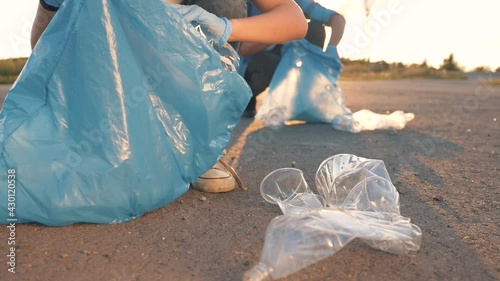 Plastic waste environmental pollution concept. Teamwork of volunteers to clean up plastic on the beach. Volunteers collect garbage in garbage bags. Plastic pollution and environmental problem concept.