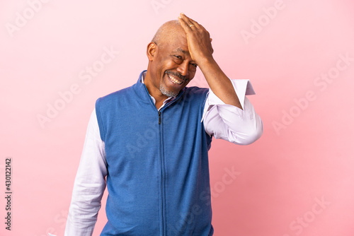Cuban senior isolated on pink background has realized something and intending the solution © luismolinero