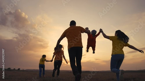 Wallpaper Mural happy family. parent a baby together run in the park at sunset silhouette. people in the park concept. mom dad daughter and son joyful run. happy family and fun baby child summer kid dream concept Torontodigital.ca