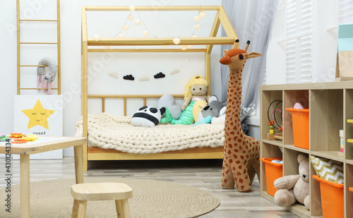 Cute child's room interior with toys and wooden furniture