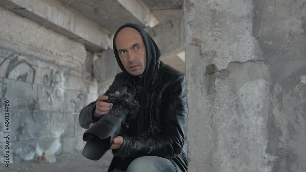 A man with a camera secretly takes pictures of the object. A private investigator or investigative journalist. A man with a camera secretly takes pictures of the object. A private investigator or investigative journalist.
