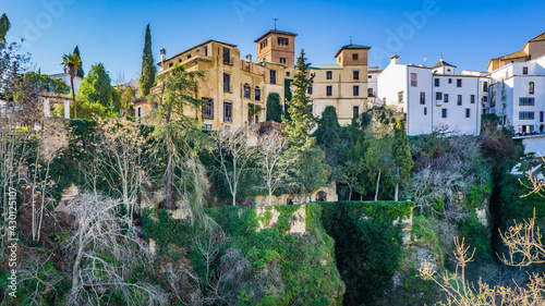 View on the Casa del Ray Moro, on the other side of the Tajo gorge, from the Cuenca gardens (Jardines de Cuenca) in Ronda, Andalusia (Spain)