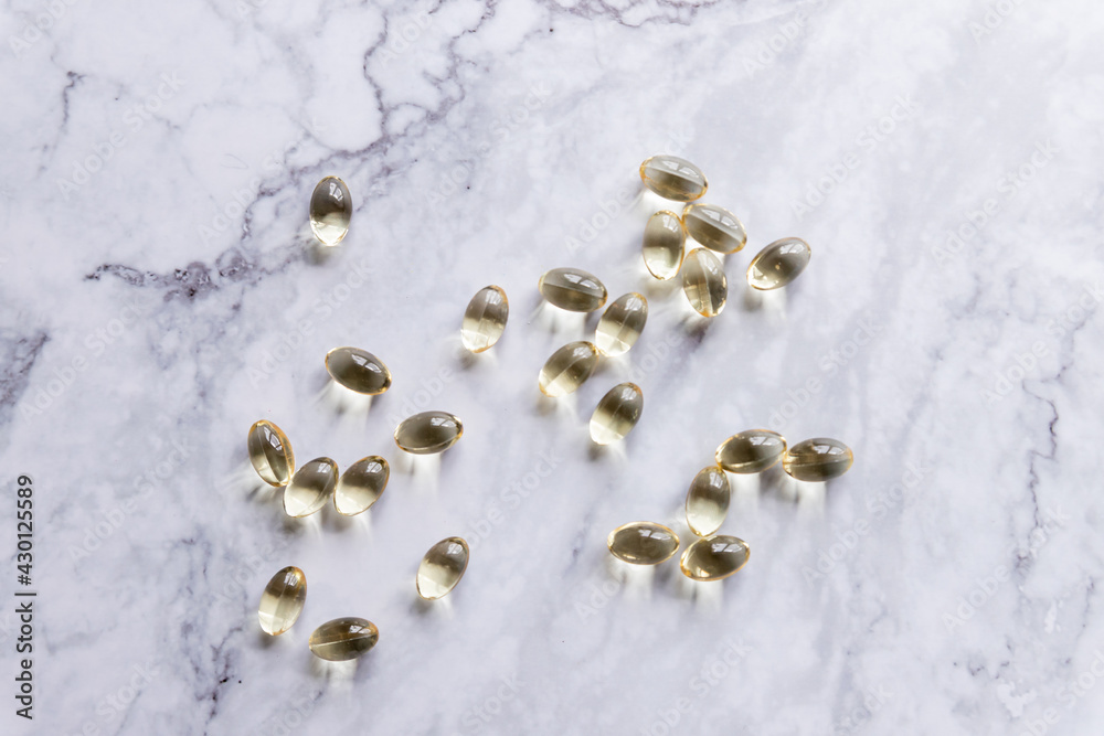 fish oil capsules isolated on marble background.Healthy Vitamins, supplements ,Omega 3. Healthy lifestyle.Copy space.