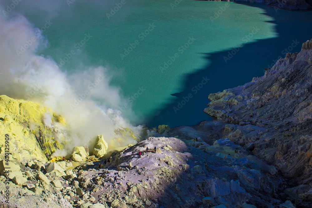 Smoke of sulfur toxic gas in the acidic crater lake of Kawah Ijen volcano, Banyuwangi, East Java, Indonesia. Mount Ijen is the famous tourist attraction, where sulfur is mined.