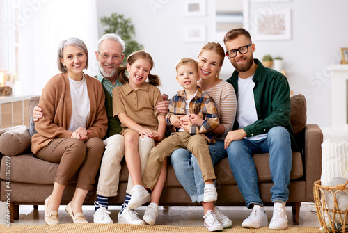 Valokuva Beautiful multi generational family sitting together on couch at home and smilin