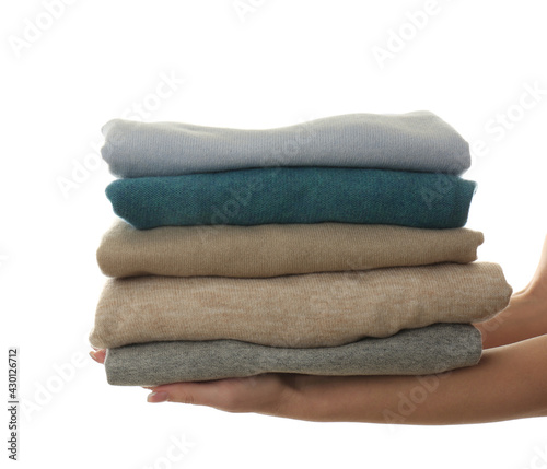 Woman with folded cashmere clothes on white background, closeup