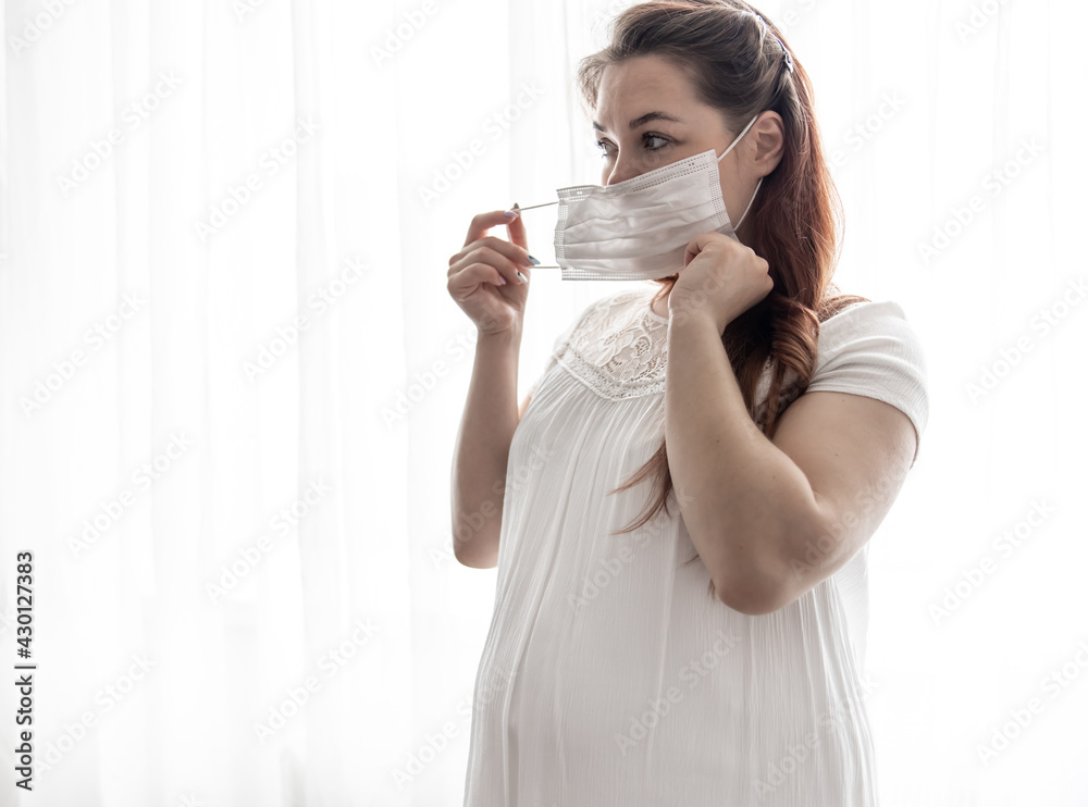 Young pregnant woman in protective medical mask copy space. Young pregnant woman in protective medical mask copy space.