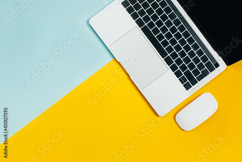 Slika na platnu laptop on a yellow blue background. Top view. Free space for text