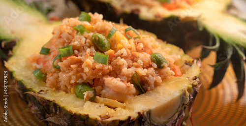 Carved pineapple stuffed with fresh pineapple tomato sauced seafood fried rice.