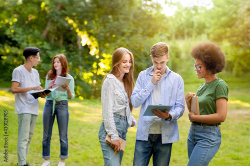Multi-ethnic group of students spending time together outdoors at college campus