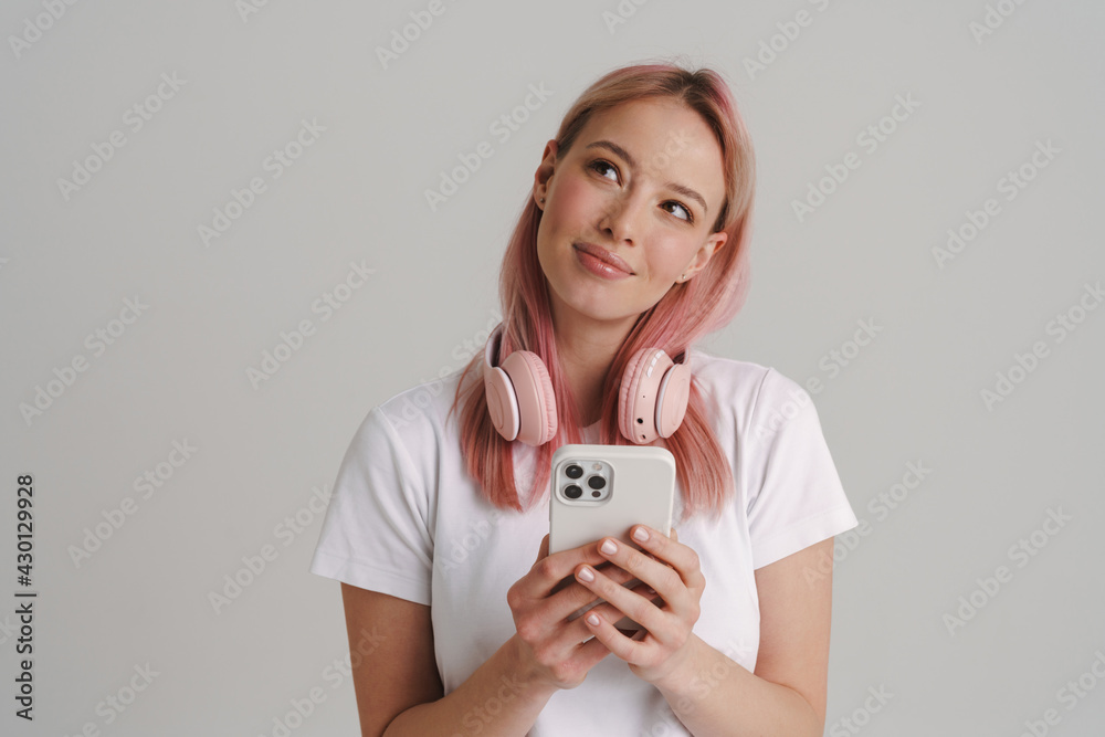 Young european woman with headphone smiling and using cellphone Young european woman with headphone smiling and using cellphone
