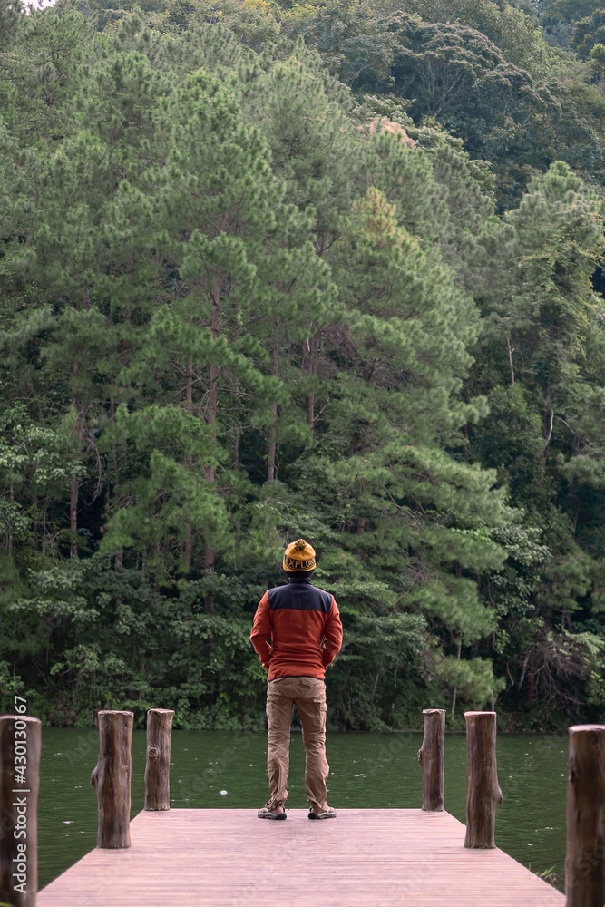 Happy traveler man standing and looking Nature view, solo tourist in sweater traveling at Pang Oung, Mae Hong Son, Thailand. travel, trip and vacation concept