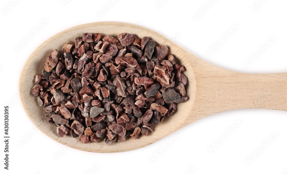 Chopped cocoa pieces pile in wooden spoon isolated on white background, top view Chopped cocoa pieces pile in wooden spoon isolated on white background, top view