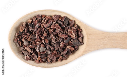 Chopped cocoa pieces pile in wooden spoon isolated on white background, top view