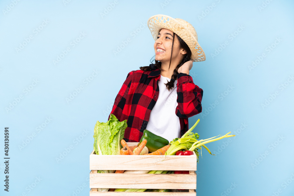 Young farmer Woman holding fresh vegetables in a wooden basket thinking an idea
