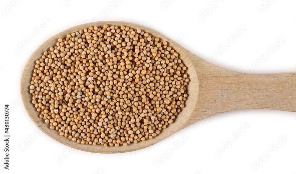 Yellow mustard seeds in wooden spoon isolated on white background, top view Yellow mustard seeds in wooden spoon isolated on white background, top view